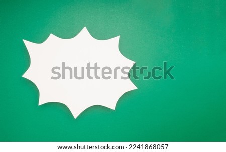 A blank white comic speech bubble on a green background. Space for text. Top view
