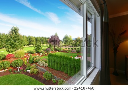 Impressive backyard landscape design with trees, bushes and sawdust. Beautiful view from bedroom window