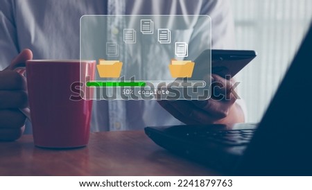Data transfer concept. Copy files, data exchange, Files transfer. Person hand using mobile smart phone and laptop computer waiting for transfer file process with loading bar icon on virtual screen. Royalty-Free Stock Photo #2241879763
