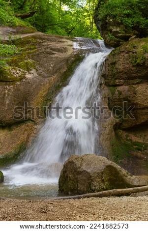 A mountain river in a natural channel with rapids and waterfalls.