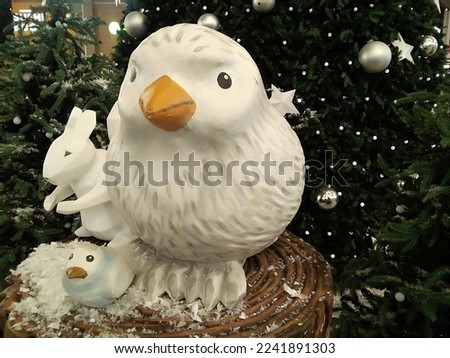  Plastic chick is flying under chrystmas tree

