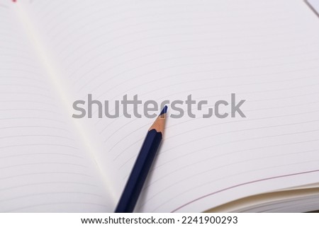 a blue pencil in an open notebook