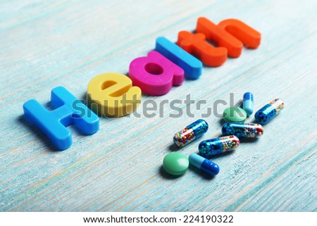 Health word formed with colorful letters on wooden background