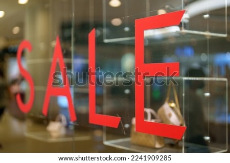 Annual clearance sale letters on a glass inside the popular clothing store. Selective focus image.