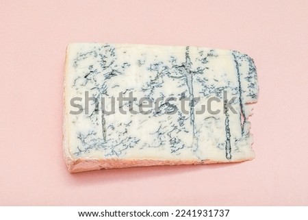 Italian traditional gorgonzola soft cheese with mold. Top Italian cheese - gorgonzola. Blue cheese family. Slice of blue italian cheese - gorgonzola, on pink background. Royalty-Free Stock Photo #2241931737