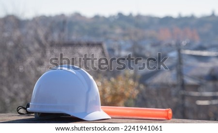 Security guard image. Hard hat and red stick.Hard hat and cityscape.