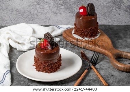 Chocolate and strawberry cake on a dark background. Biscuit, chocolate and fruit cake prepared with special cream. Bakery products