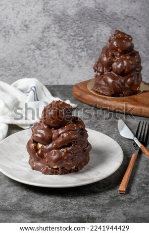 Chocolate cake on a dark background. Dessert with chocolate sprinkled on profiteroles grains. Bakery products