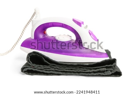 Electric iron and clothes isolated on white background