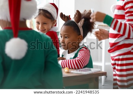 Little African-American girl in Christmas costume at workshop for Ebru painting