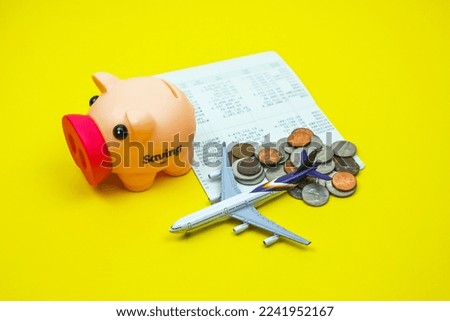 Coins in piggy savings jar, coins, account book, airplane, savings for traveling vacation financial plan concept, budgeting
