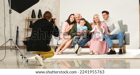 Happy family posing for photographer in studio