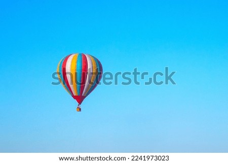 a multicolored balloon in a blue sky