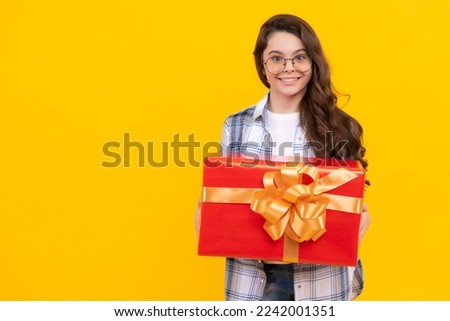 teen girl with present isolated on yellow background with copy space. teen girl in glasses