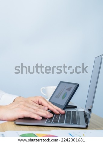 close up executive ​using laptop while working on working desk with white copy space background for making meeting presentation, professional businessman busy work on the business data graph