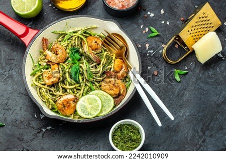 zucchini pasta with shrimps and pesto sauce in pan. keto low carb diet. banner, menu, recipe place for text, top view.
