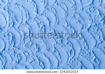 Light blue bentonite clay (face cream, alginate facial mask, body wrap, hair conditioner) texture close up, selective focus. Abstract background with brush strokes. 