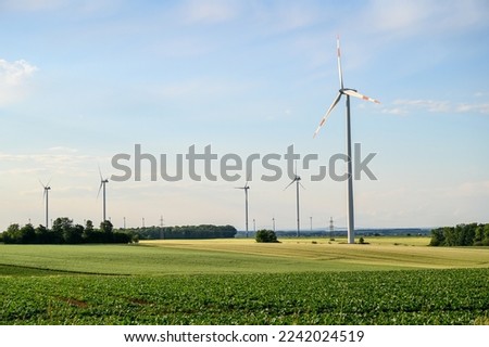 Windmills on Wind farm. Wind turbines against blue sky. Producing renewable energy. 