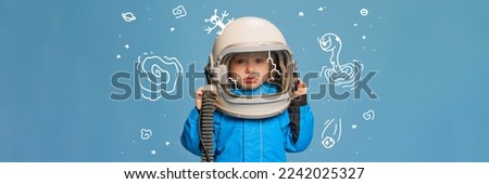 Creative design with drawn elements. Portrait of little boy, child in costume of astronaut over blue background. Feeling sad. Concept of imagination, childhood, creativity, dreams, ad