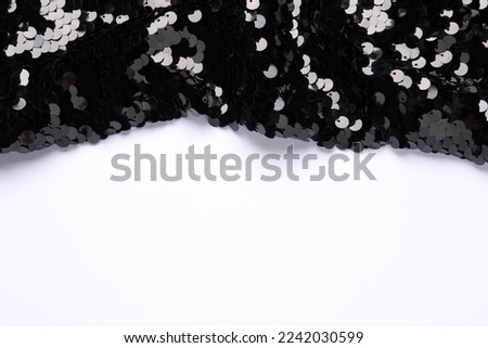 Black shiny sequin fabric on white background, top view. Space for text