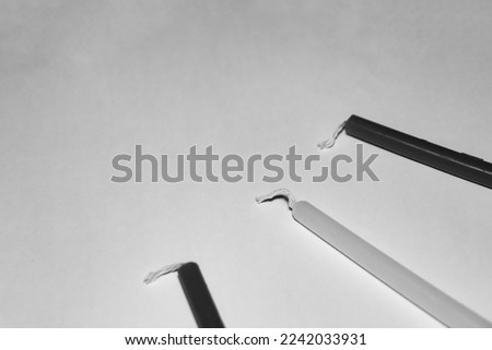 Black and white three Hanukkah candles in the corner leaving blank negative space isolated on white background