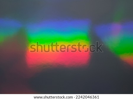 macro photo of abstract pastel iridescent holographic foil background with light leaks. holo color wrinkled material. cool glitter surface with shiny rainbow feel. 