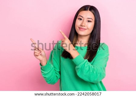 Photo of young satisfied positive cute chinese lady wear green trendy pullover point finger mockup new media show isolated on pink color background