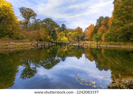 A lake reflecting surrounding green trees at sunrise in Beckley creek park in Louisville, Kentucky Royalty-Free Stock Photo #2242083197