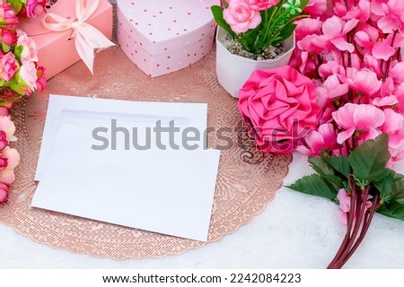 Rectangle greeting card above an rounded tablecloth surrounded by colorful decoration with valentine themed, and a white fluffy carpet as the background