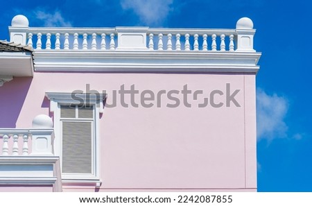 Building wall exterior with blue sky outside and white window on pink color on daylight well free space for text promotions 