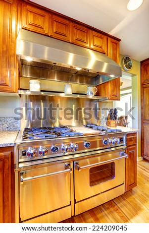 Storage combination with shiny steel modern stove and  hood