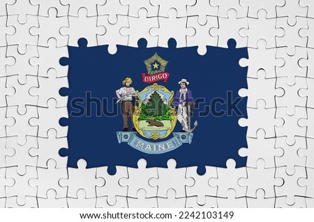 Maine US state flag in frame of white puzzle pieces with missing central parts