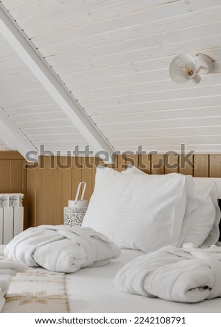 Close-up of the hotel room with white linens and white bathrobes on the bed. High quality photo