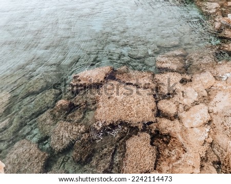 Rocky seabed with clear blue water. Lagre stones in the water. Autumn soft background. Mediterranean Sea coast near Ayia Napa, Cyprus.