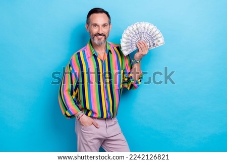 Photo of positive successful man wear stylish clothes hold savings luxurious life summer vacation isolated on blue color background