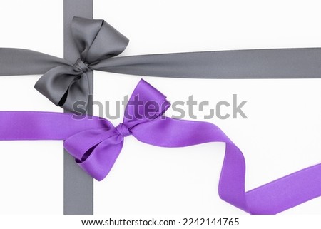 Satin ribbon bows for gift pack in gray and purple colors, isolated on white background. Background with ribbon knot on white background.	