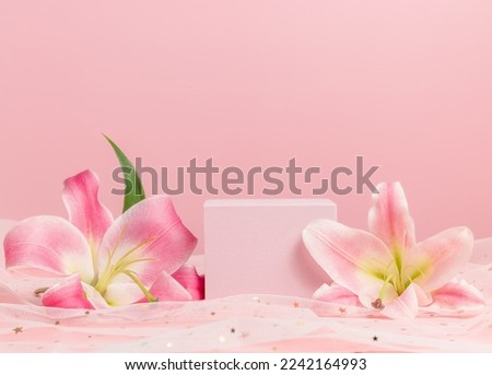 Cube podium with pink lilies on pink background. Display with flowers for product presentation. Romantic, valentine concept Royalty-Free Stock Photo #2242164993