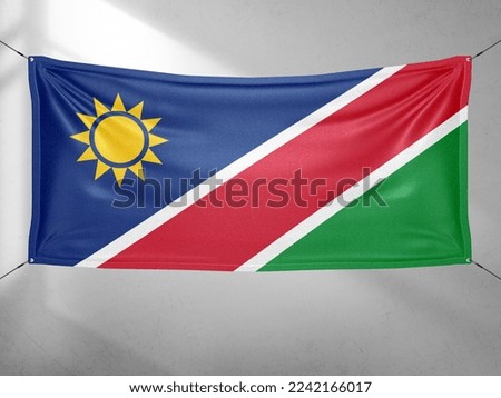 Namibia national flag cloth fabric waving on beautiful grey sky.