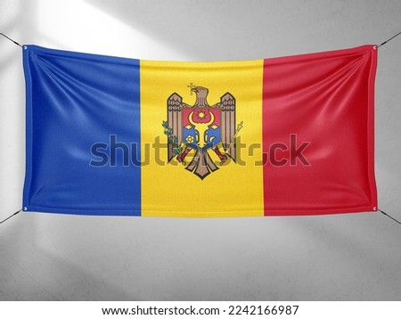 Moldova national flag cloth fabric waving on beautiful grey sky.