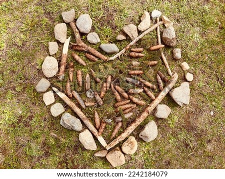 Rustic heart out of sticks and rocks on grass