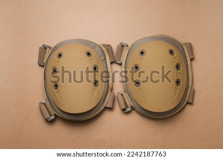 Protective knee pads for soldiers on a beige background Royalty-Free Stock Photo #2242187763