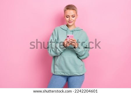 Photo of young addicted user influencer popular vlogger girl hold her smartphone concentrated typing check account isolated on pink color background