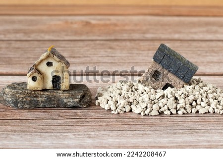 Two miniature houses in sand and on rock (stone). Copy space. A close-up. Solid foundation gospel parable of Jesus Christ, obedience, and faith in God. Christian biblical concept. Royalty-Free Stock Photo #2242208467