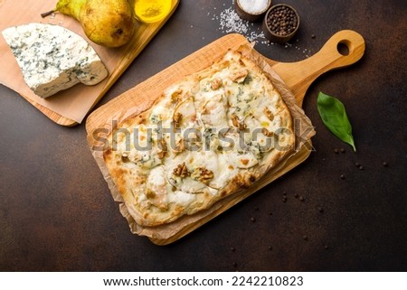 pizza with pear and Gorgonzola on Roman dough, pinsa on dark brown table top view Royalty-Free Stock Photo #2242210823