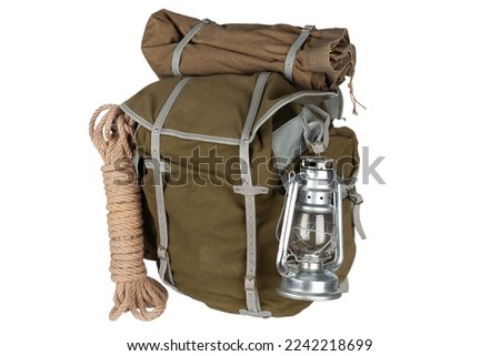 Antique vintage backpack with rope and gas lantern isolated on white background
