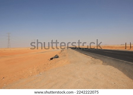 Long straight road through the Western Desert (Sahara) in southern Egypt. Royalty-Free Stock Photo #2242222075