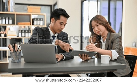 Smart and professional Asian male financial analyst working with a colleague in the office. businesspeople concept
