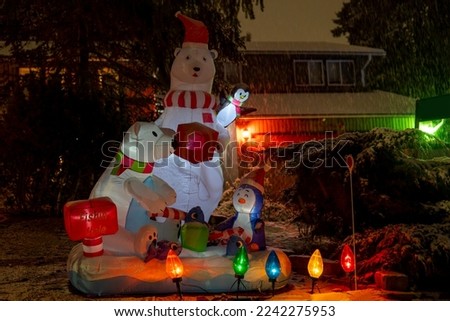 Glowing at night bear and penguins figures. Beautiful Christmas illuminated decoration outside the house. Selective focus, blurred background