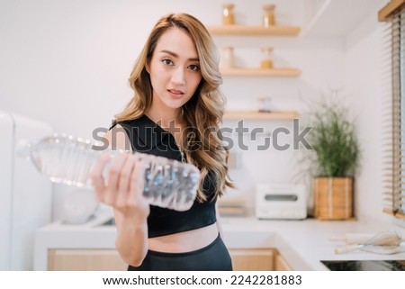 gorgeous woman using recycled bottle dumbbell to exercise and save environment. beautiful woman holding plastic water bottle to exercise instead. motivated smart woman reuse plastic for workout tool.