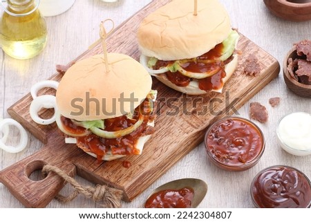 A hamburger, or simply burger, is a food consisting of fillings usually a patty of ground meat, typically beef, placed inside a sliced bun or bread roll. Hamburgers are often served with cheese, 